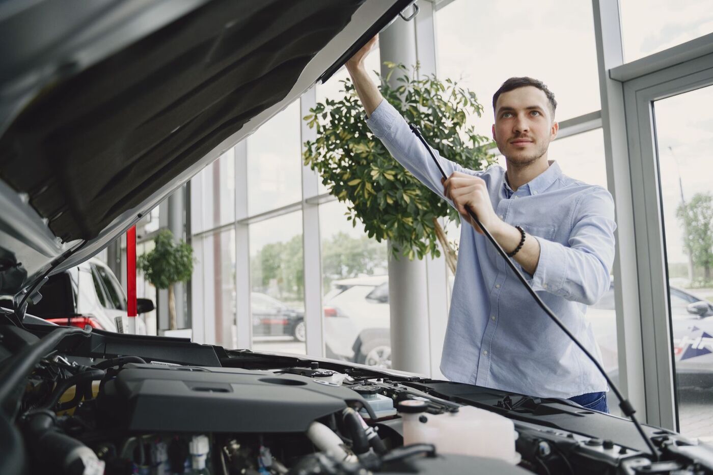 Someone inspecting an engine bay with the bonnet raised